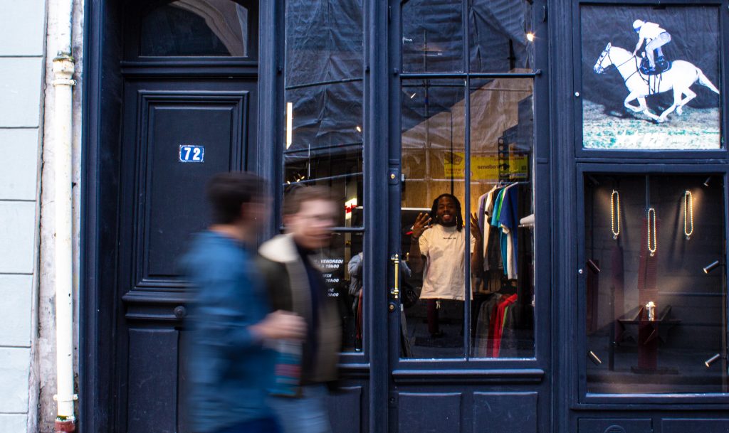 photo d'un homme sourainte à travers une boutique d'habits